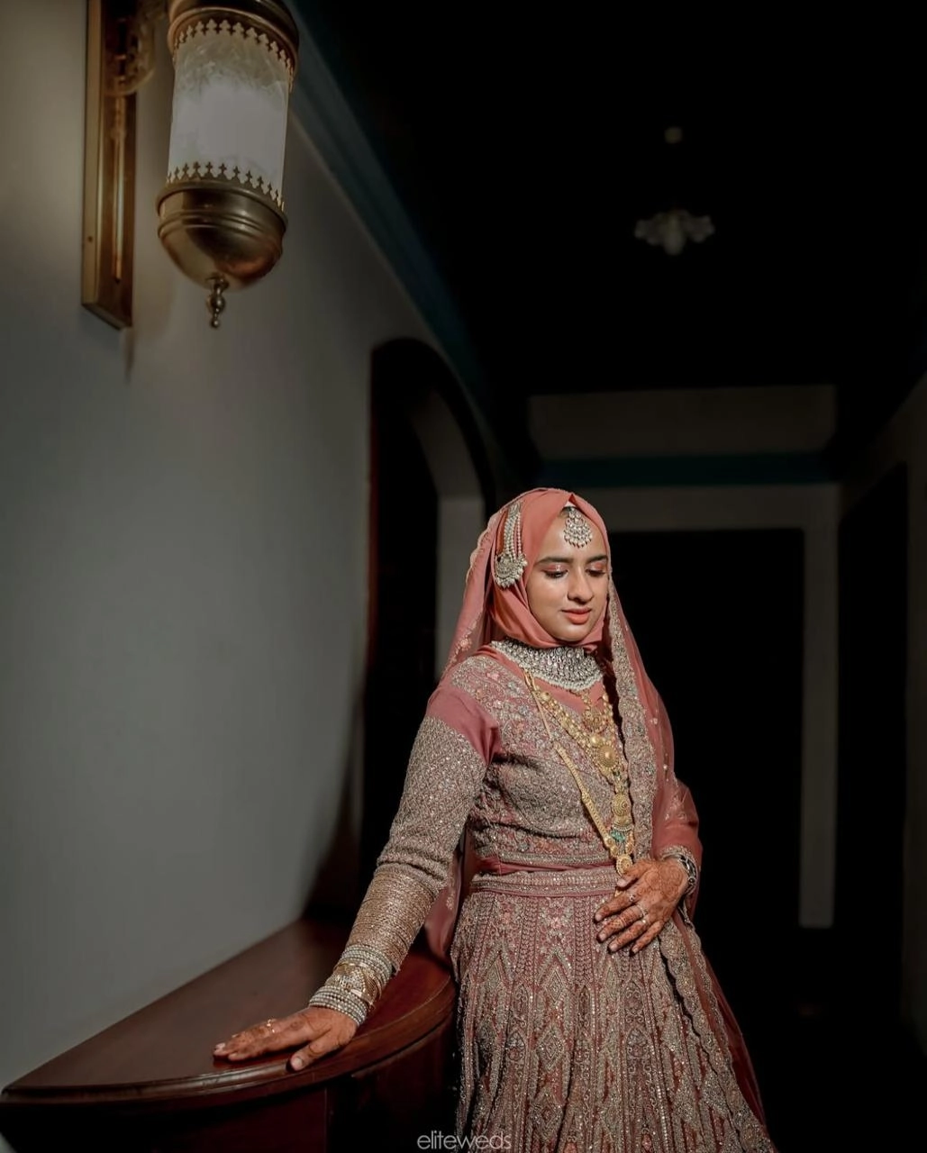 A bride standing in indoor, Clicked by the best wedding photographer in kannur