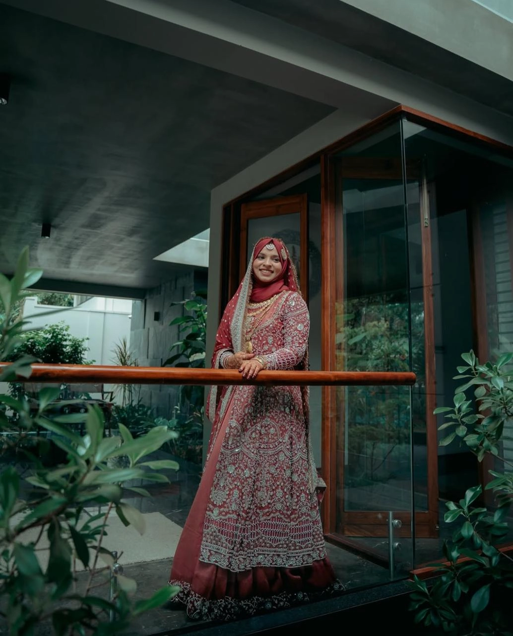 A bride standing in a balcony with a smile, Clicked by the best wedding photographer in kannur